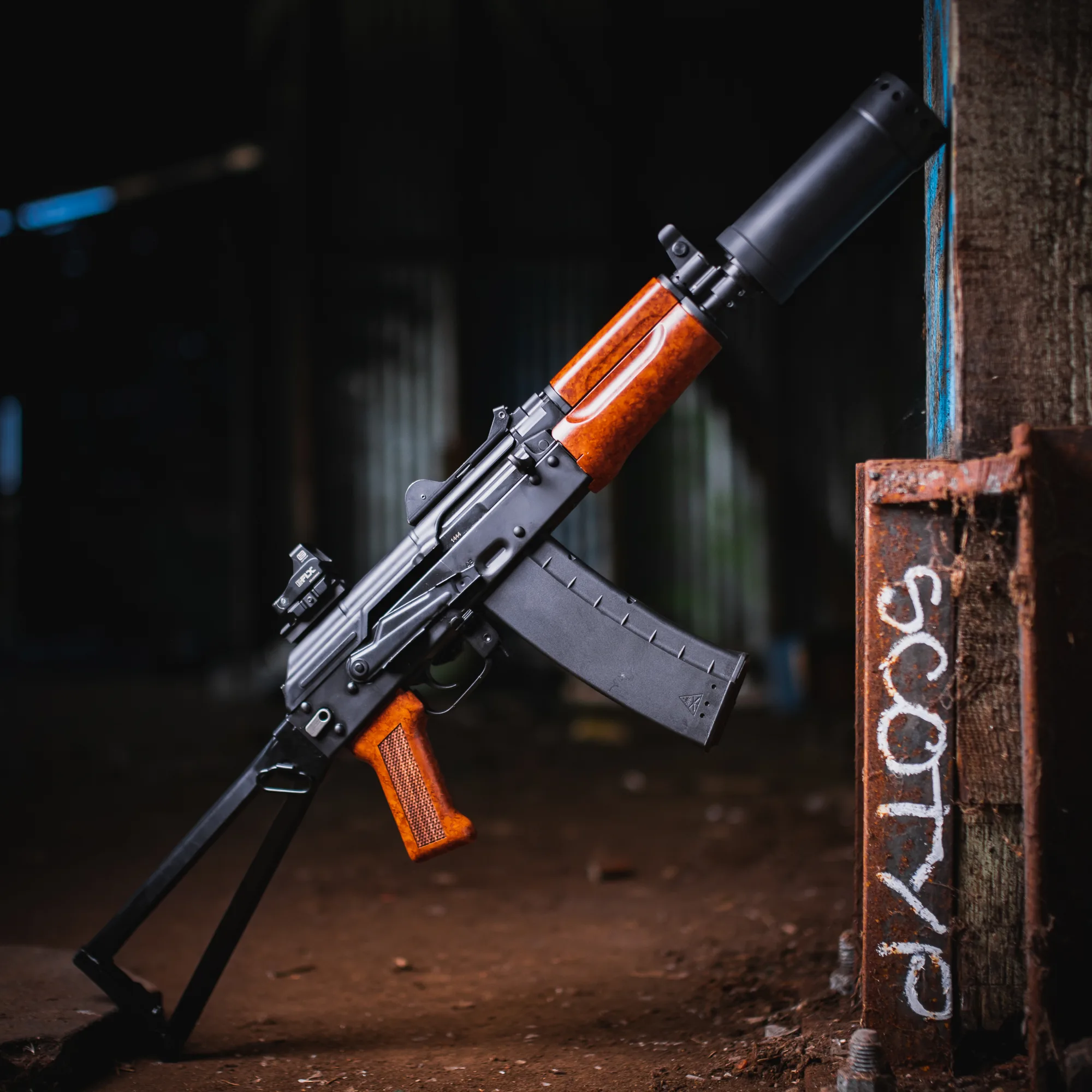 Suppressed rifle leaning against a steel post