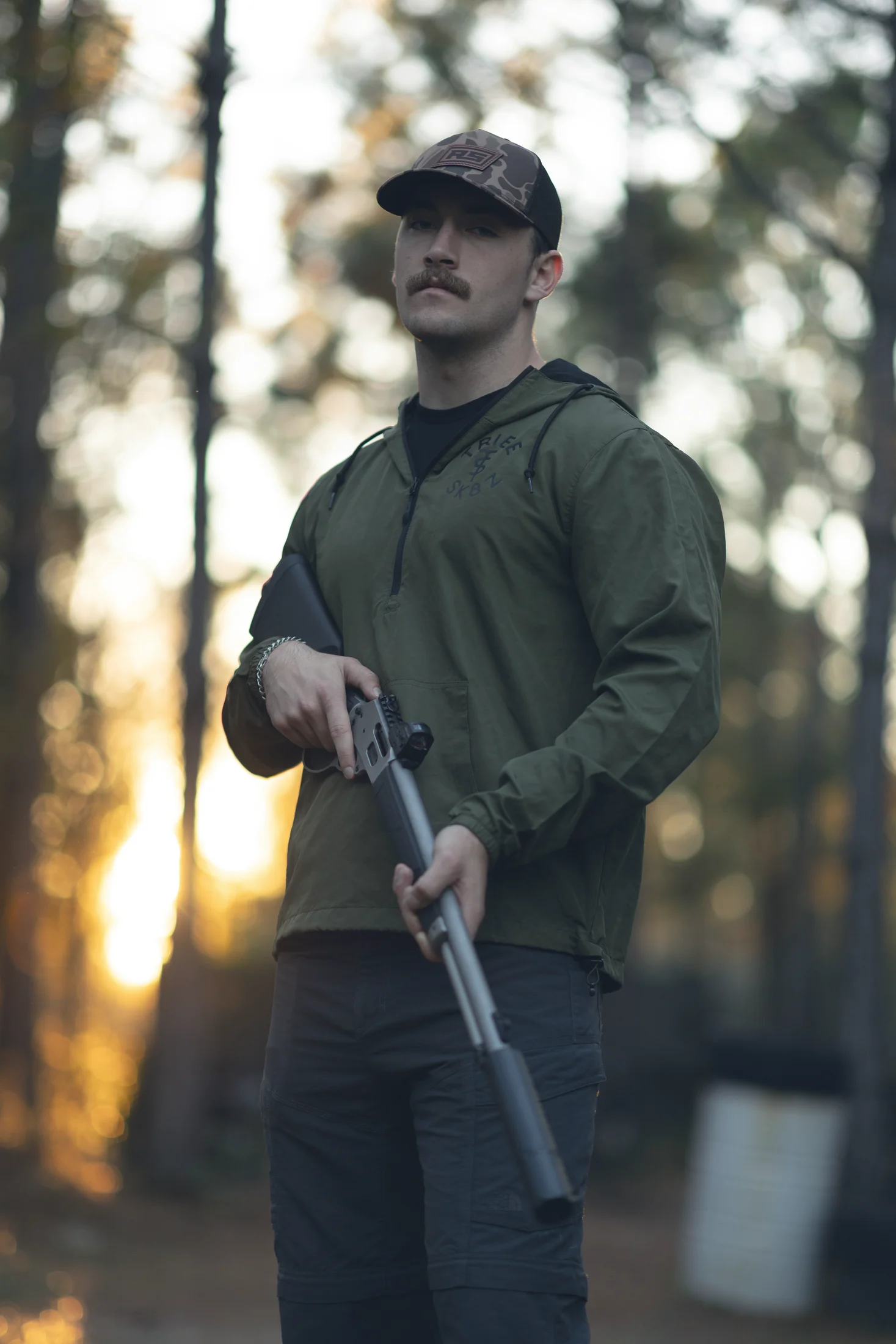 Hunter at sunset holding a suppressed lever gun