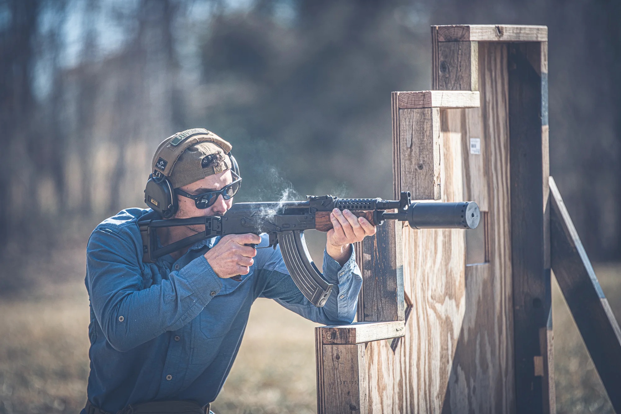Shooter running a suppressed rifle behind a barricade